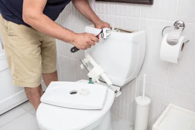 Master plumber performing toilet installation in Anoka County Minnesota residential bathroom